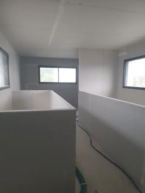 Une pièce séparée par des cloisons en plaques de plâtre à mi-hauteur