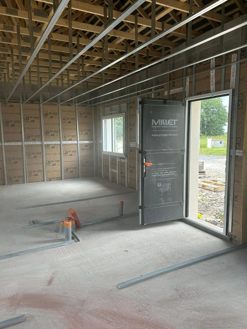 L’entrée d’une maison isolée en laine kraft autour de la porte d’entrée, rails au sol
