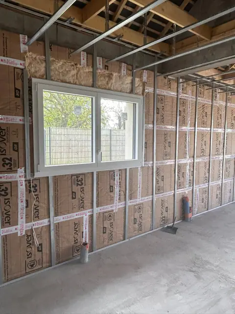 Un mur isolé en laine minérale kraft autour d’une fenêtre, ossature du plafond posée