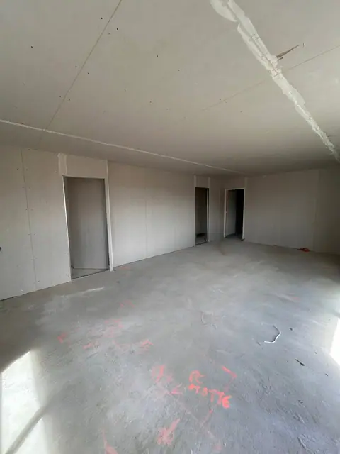 Une grande pièce plaquée, des cloisons et leurs ouvertures de portes