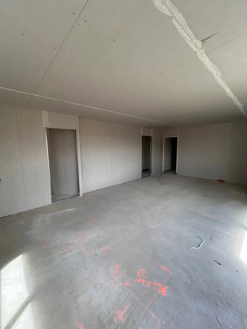 Une grande pièce plaquée, des cloisons et leurs ouvertures de portes