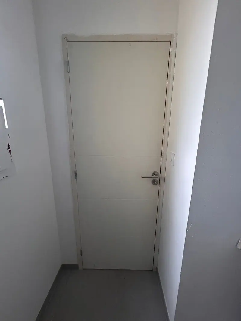 Une porte intérieure blanche posée au bout d’un dégagement