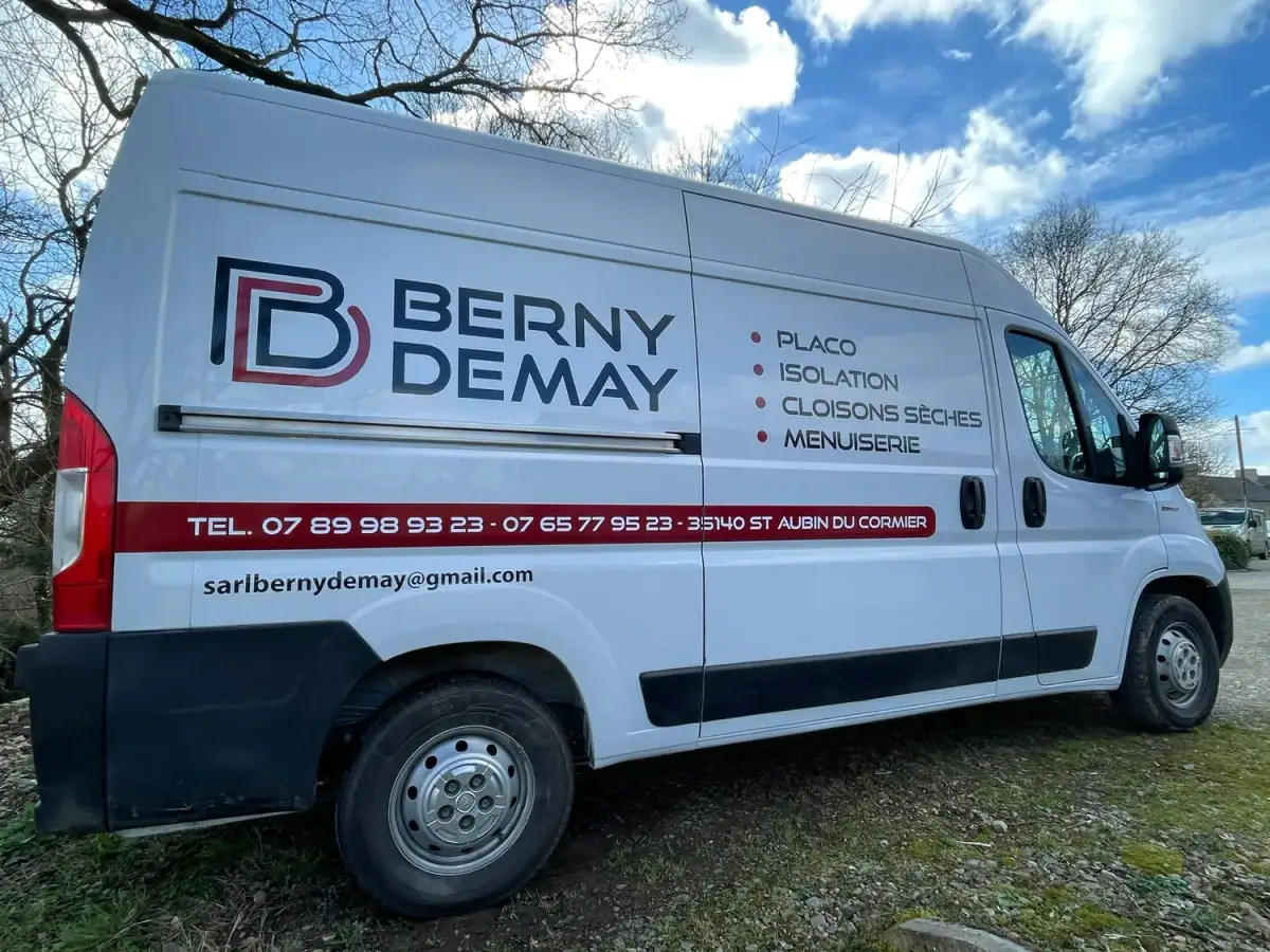 Le camion blanc de Berny & Demay, lettré « Placo, Isolation, Cloisons sèches, Menuiserie », garé dans l’herbe