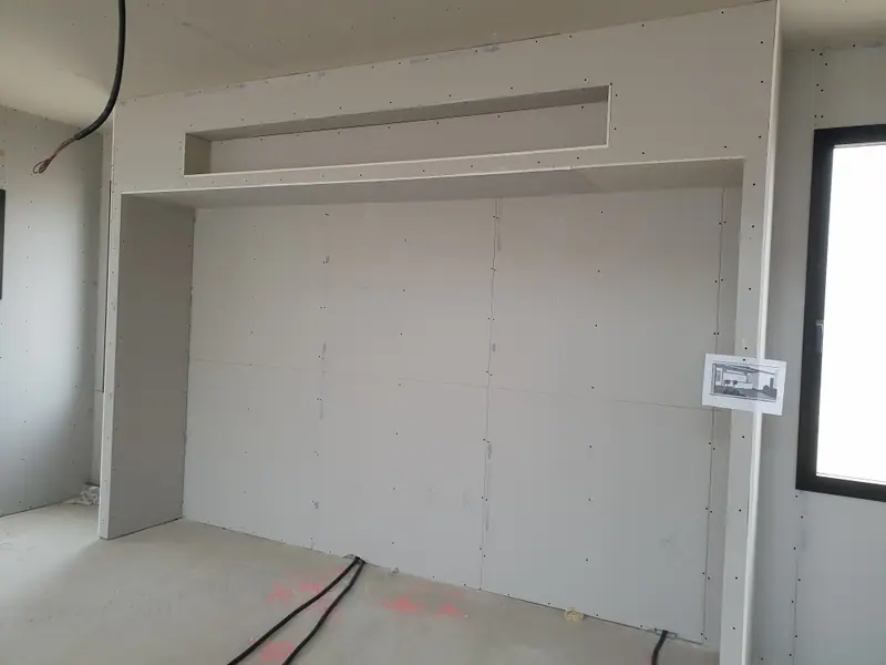 Un mur en plaques de plâtre avec un caisson et une niche, avant les bandes